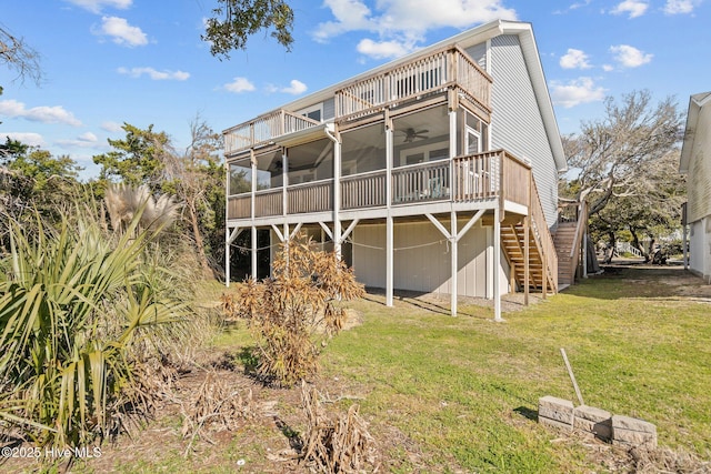 rear view of property featuring a sunroom, stairs, a wooden deck, a ceiling fan, and a lawn