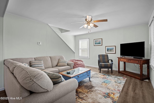 living room with baseboards, ornamental molding, wood finished floors, and a ceiling fan