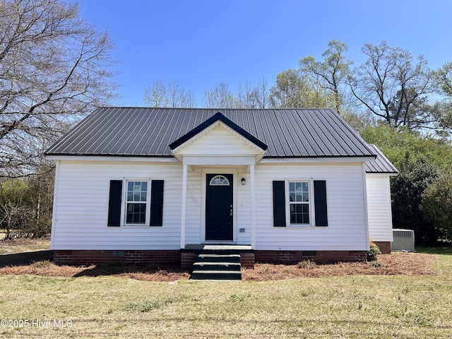 view of front of home with metal roof, a front lawn, and crawl space