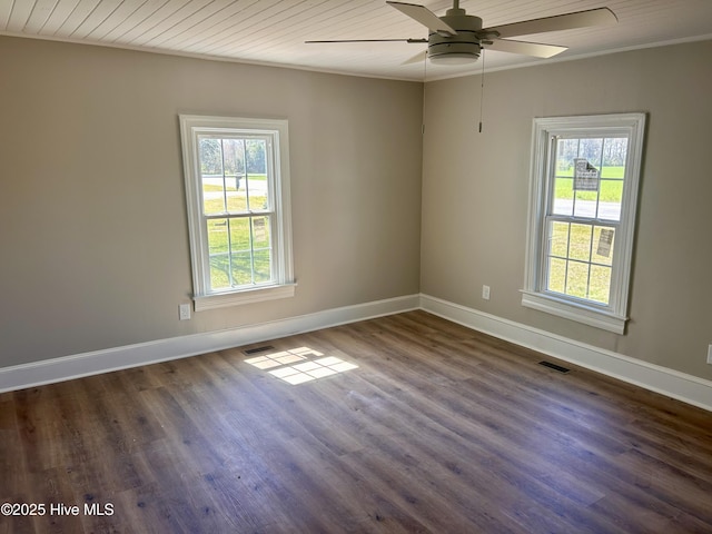 empty room featuring baseboards, dark wood finished floors, visible vents, and plenty of natural light