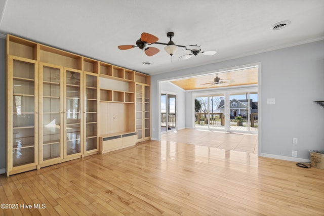 unfurnished living room with visible vents, hardwood / wood-style flooring, baseboards, ceiling fan, and ornamental molding