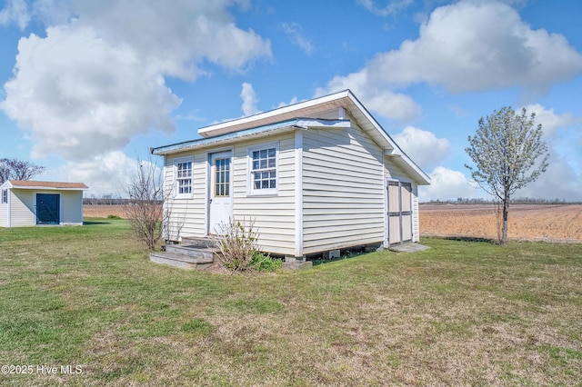 exterior space featuring a lawn, entry steps, and an outbuilding