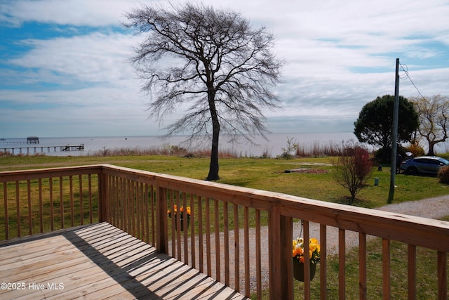 wooden deck with a lawn and a water view