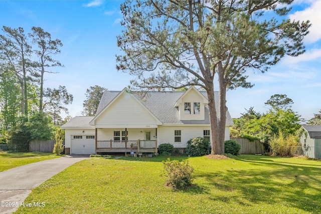 view of front of home with driveway, fence, a garage, a shingled roof, and a front lawn
