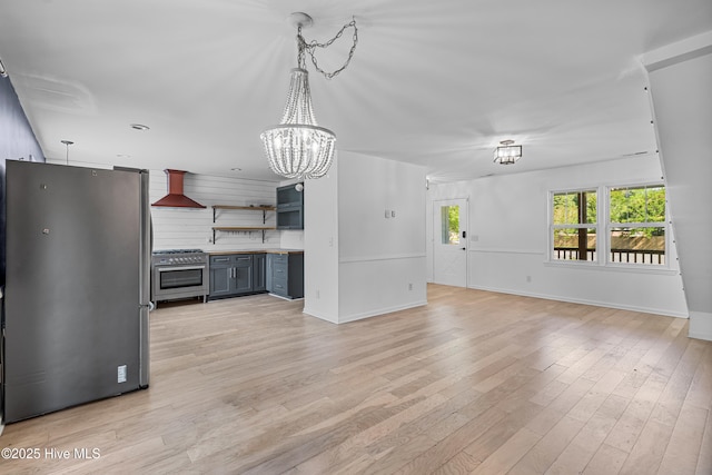 unfurnished living room with light wood-style flooring, baseboards, and a notable chandelier