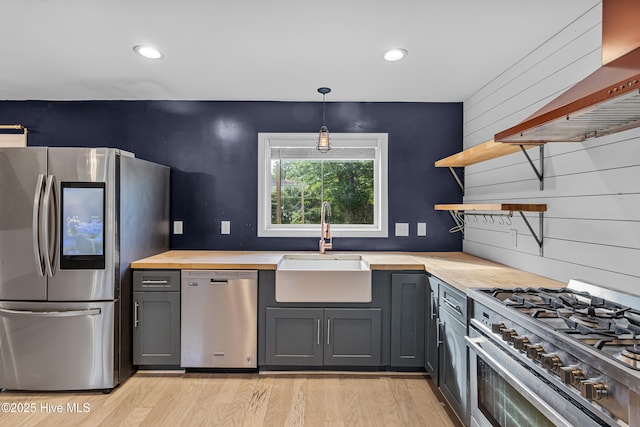 kitchen featuring a sink, gray cabinets, wood counters, open shelves, and appliances with stainless steel finishes