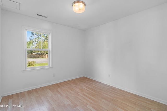 unfurnished room with baseboards, light wood-style flooring, and visible vents