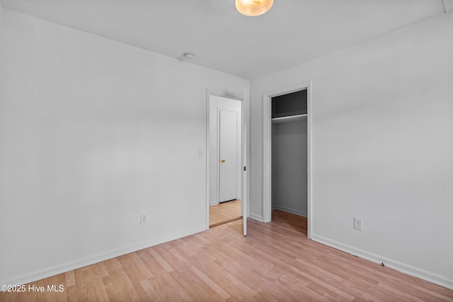 unfurnished bedroom with baseboards, a closet, and wood finished floors