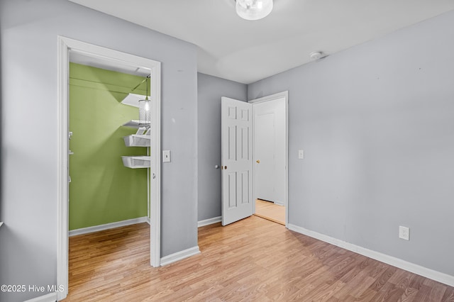 unfurnished bedroom featuring baseboards and light wood-style floors