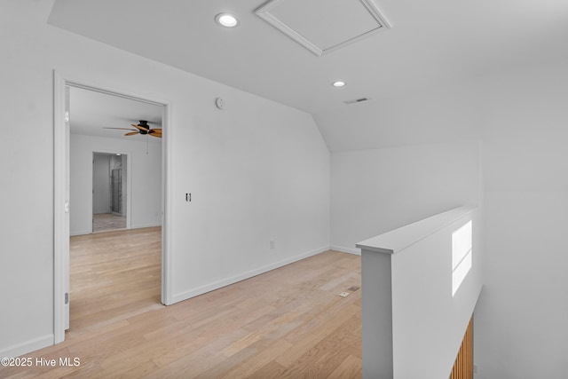 empty room featuring attic access, light wood-type flooring, lofted ceiling, and recessed lighting