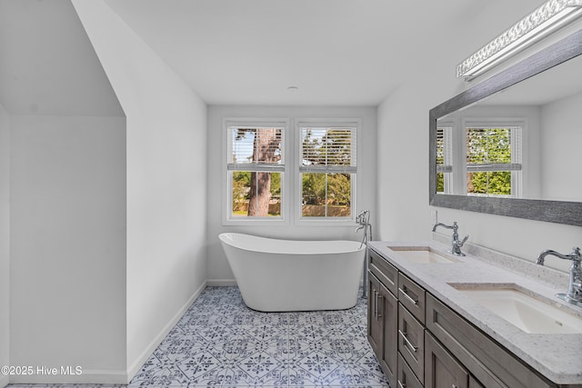 full bathroom featuring a wealth of natural light, a soaking tub, and a sink
