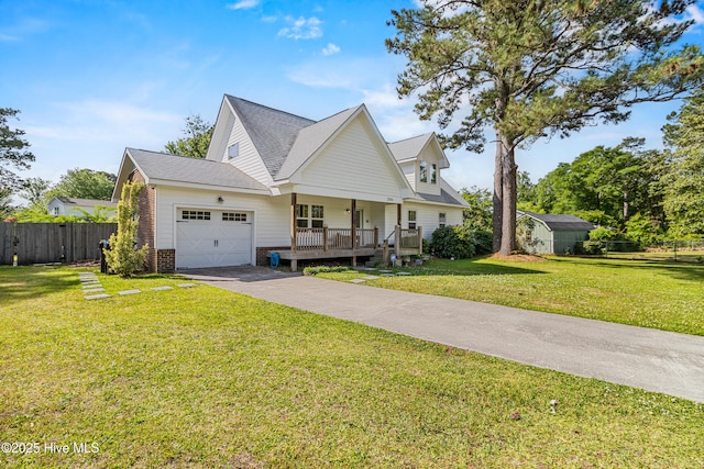 view of front of house featuring a porch, fence, an attached garage, concrete driveway, and a front lawn