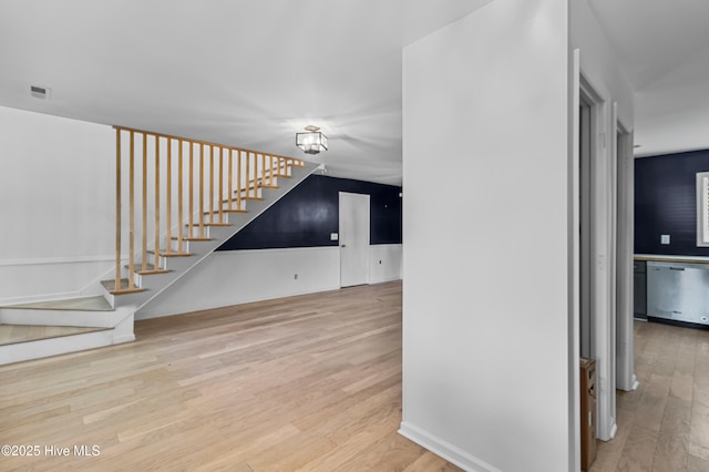 unfurnished living room featuring visible vents, wood finished floors, and stairs