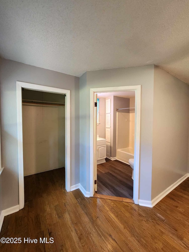 106 Hunters Trl E, Elizabeth City, NC 27909 - unfurnished bedroom featuring baseboards, a closet, wood finished floors, and a textured ceiling