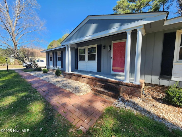 106 Hunters Trl E, Elizabeth City, NC 27909 - doorway to property with a lawn, board and batten siding, and a porch