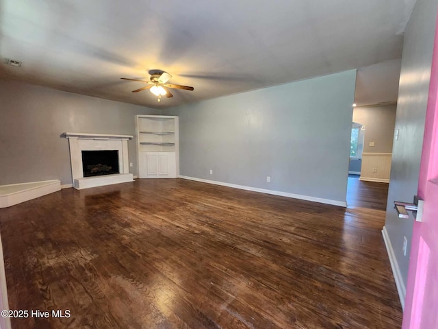 106 Hunters Trl E, Elizabeth City, NC 27909 - unfurnished living room with dark wood-style floors, visible vents, a fireplace with raised hearth, and ceiling fan