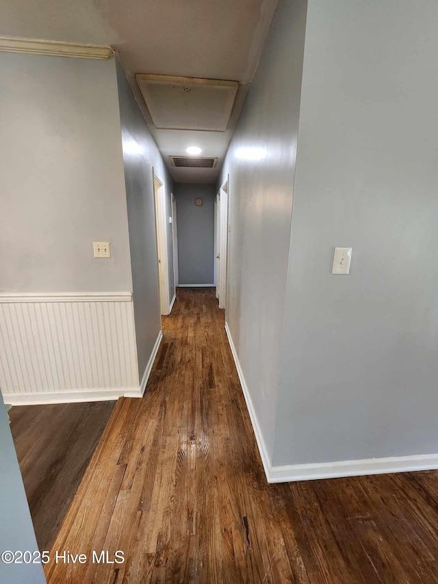 106 Hunters Trl E, Elizabeth City, NC 27909 - hallway featuring a wainscoted wall, visible vents, baseboards, wood finished floors, and attic access