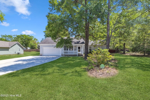 view of property hidden behind natural elements with fence, an attached garage, driveway, and a front yard