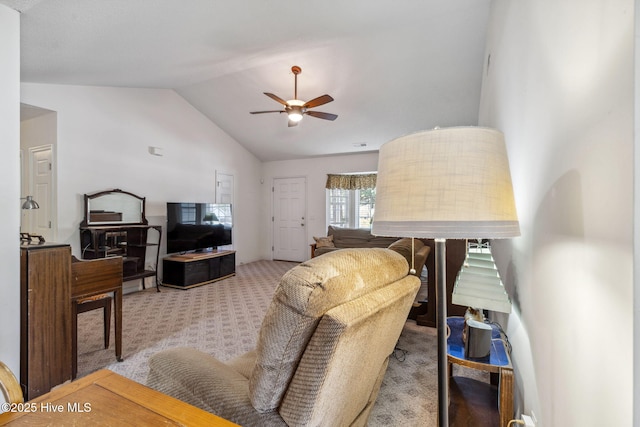 living area with ceiling fan, vaulted ceiling, and carpet