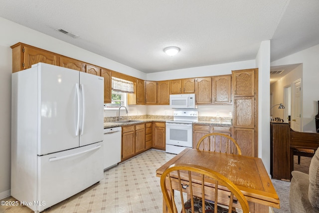 kitchen featuring visible vents, a sink, light countertops, light floors, and white appliances