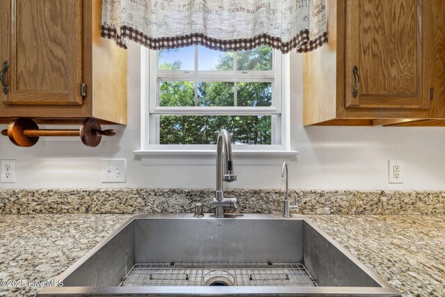 interior details featuring brown cabinetry and a sink