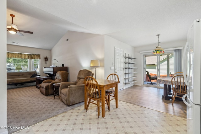 living area with ceiling fan, baseboards, wood finished floors, lofted ceiling, and visible vents