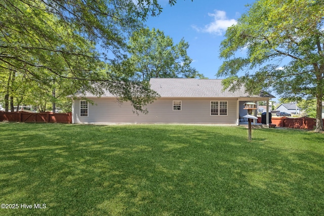 back of house featuring a lawn and a fenced backyard