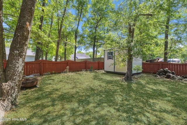 view of yard featuring a fenced backyard, an outbuilding, and a shed