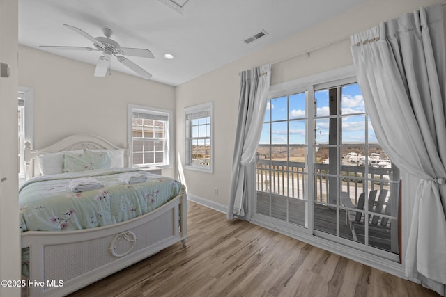 bedroom with baseboards, access to outside, visible vents, a ceiling fan, and wood finished floors
