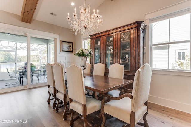 266 Twining Rose Ln, Holly Ridge, NC 28445 - dining area featuring light wood-style floors, a healthy amount of sunlight, an inviting chandelier, and visible vents