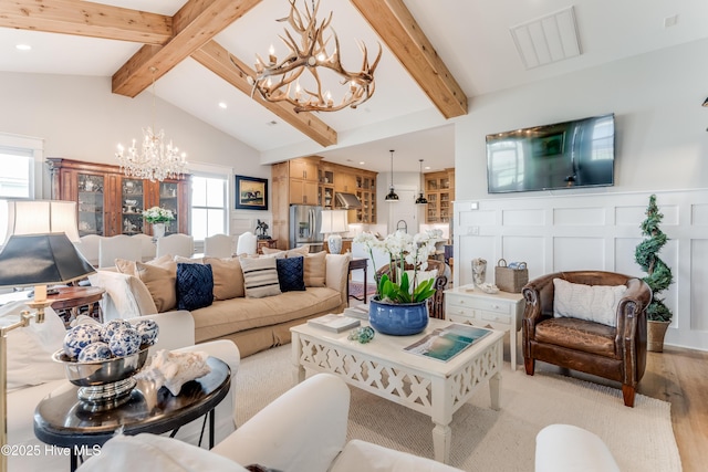 266 Twining Rose Ln, Holly Ridge, NC 28445 - living room with visible vents, a notable chandelier, light wood-style floors, vaulted ceiling with beams, and a decorative wall