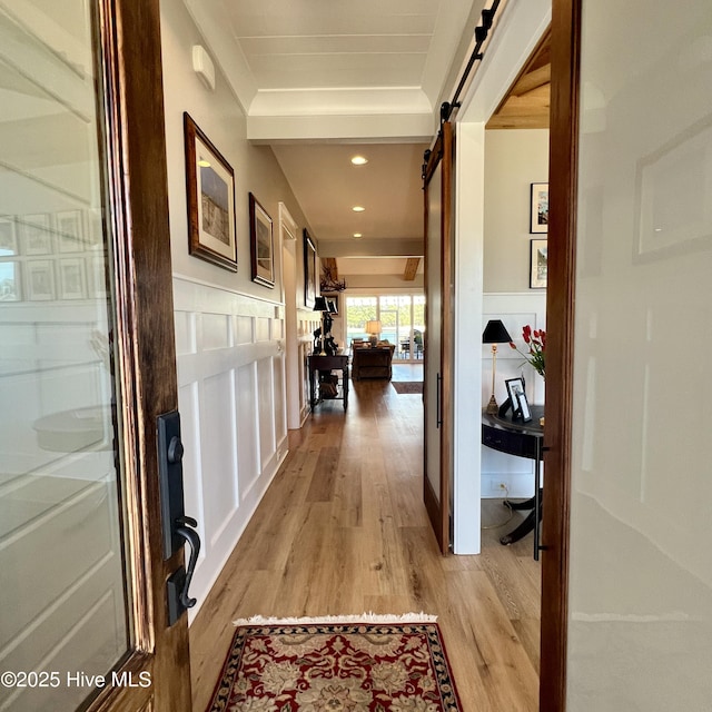 266 Twining Rose Ln, Holly Ridge, NC 28445 - corridor featuring light wood-style floors, a barn door, a wainscoted wall, and recessed lighting