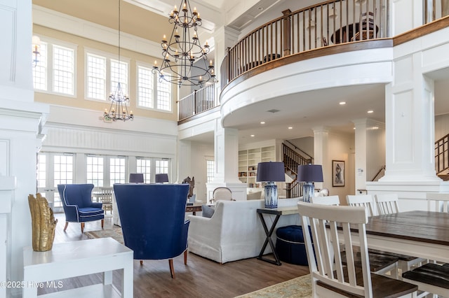 266 Twining Rose Ln, Holly Ridge, NC 28445 - living room with a high ceiling, a chandelier, wood finished floors, ornate columns, and ornamental molding