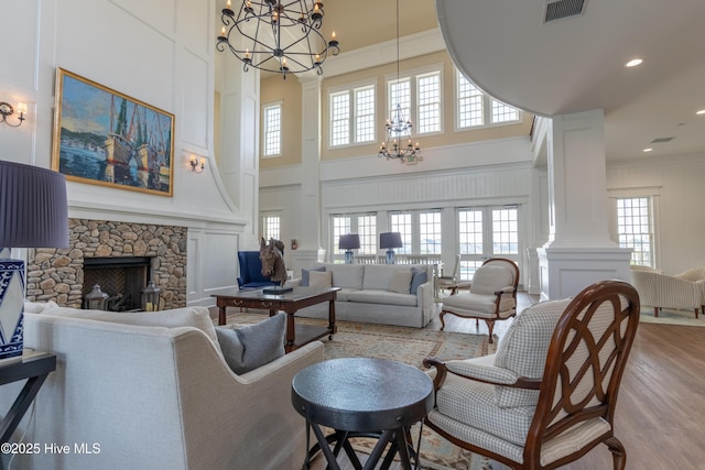 266 Twining Rose Ln, Holly Ridge, NC 28445 - living room with a high ceiling, an inviting chandelier, a decorative wall, wood finished floors, and visible vents