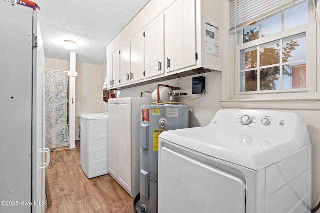laundry area with a textured ceiling, independent washer and dryer, water heater, light wood-type flooring, and cabinet space