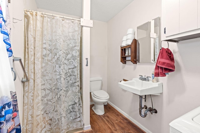 full bathroom with a textured ceiling, baseboards, toilet, wood finished floors, and a shower with curtain