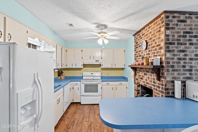 kitchen with light wood-type flooring, white appliances, under cabinet range hood, visible vents, and a ceiling fan