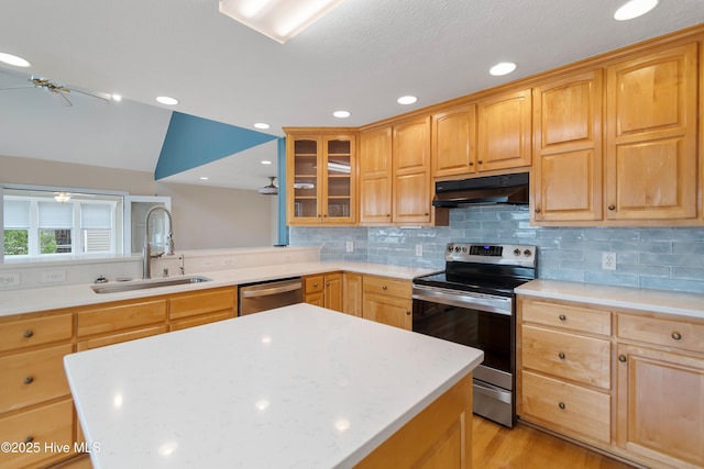 kitchen featuring a sink, tasteful backsplash, under cabinet range hood, light brown cabinets, and stainless steel appliances