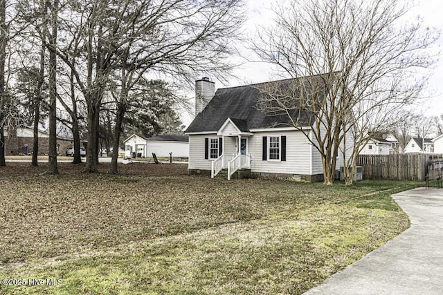 200 Emerson Dr, Rocky Mount, NC 27803 - cape cod-style house featuring roof with shingles, a front lawn, fence, and a chimney
