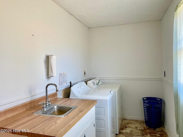 laundry room featuring a sink, washing machine and clothes dryer, laundry area, and a textured ceiling