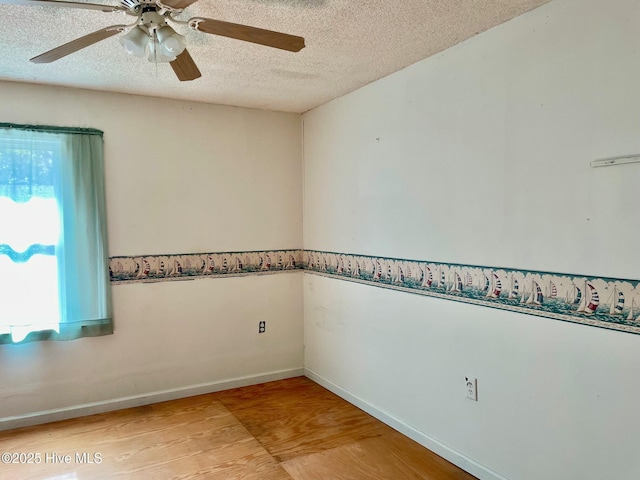 unfurnished room featuring ceiling fan, baseboards, wood finished floors, and a textured ceiling