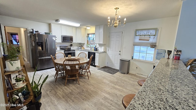 304 Mary Ave, Castle Hayne, NC 28429 - kitchen featuring stainless steel appliances, a chandelier, plenty of natural light, and white cabinetry