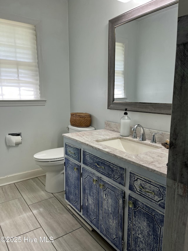 304 Mary Ave, Castle Hayne, NC 28429 - half bathroom featuring vanity, toilet, baseboards, and wood tiled floors