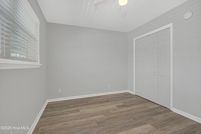 302 NE 60th St, Oak Island, NC 28465 - unfurnished bedroom featuring wood finished floors, a closet, baseboards, and ceiling fan