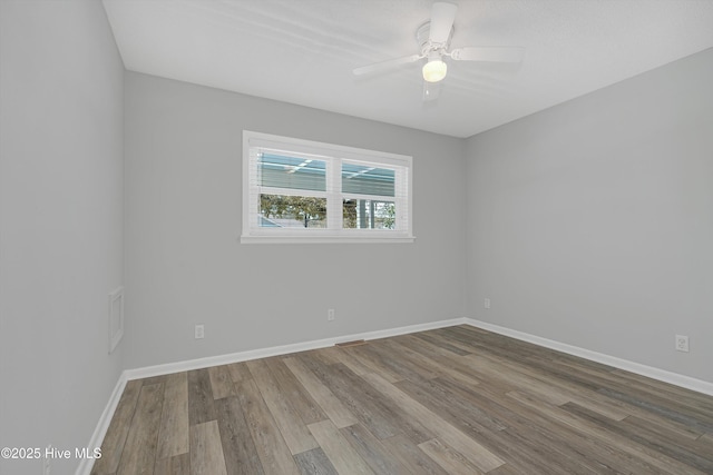 302 NE 60th St, Oak Island, NC 28465 - empty room featuring wood finished floors, baseboards, and a ceiling fan