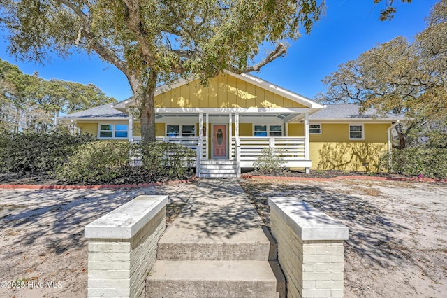 302 NE 60th St, Oak Island, NC 28465 - view of front of home featuring a porch and board and batten siding