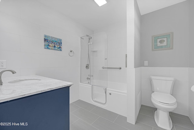 302 NE 60th St, Oak Island, NC 28465 - bathroom featuring tile walls, toilet, tile patterned floors, shower / washtub combination, and vanity