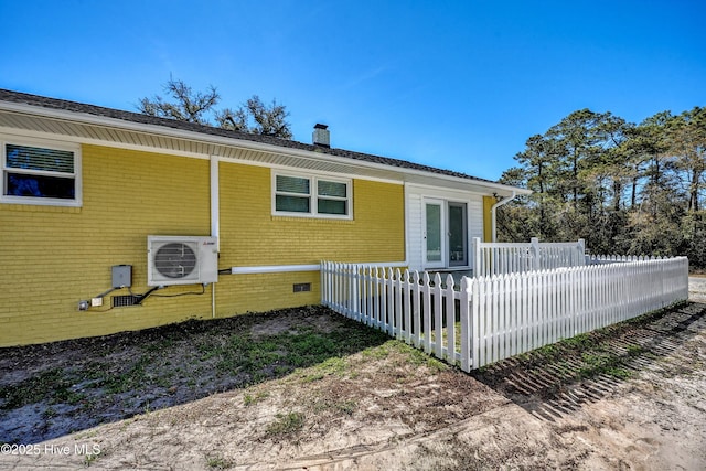 302 NE 60th St, Oak Island, NC 28465 - view of side of property featuring ac unit, a chimney, a fenced front yard, and crawl space