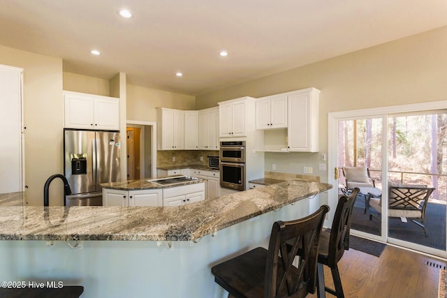 86 Sakonnet Trl, Pinehurst, NC 28374 - kitchen featuring appliances with stainless steel finishes, stone counters, a peninsula, and recessed lighting