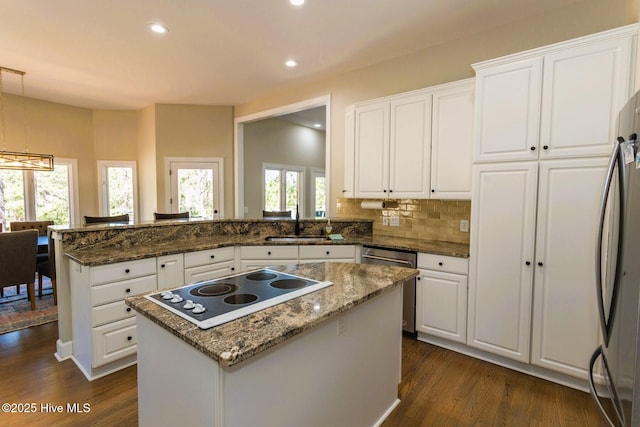 86 Sakonnet Trl, Pinehurst, NC 28374 - kitchen with stainless steel appliances, a peninsula, dark wood-type flooring, white cabinets, and a sink